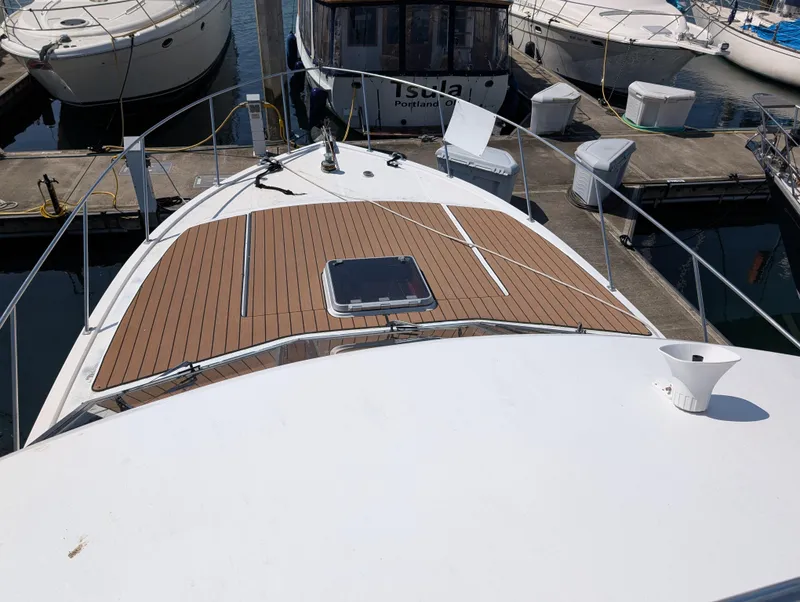 Slide: The Image of 1986 Ocean Alexander 39 Sedan yacht docked at marina, featuring teak deck and hatch. - 49