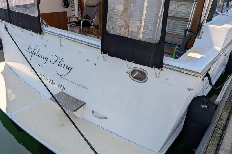 Slide: The Image of 1986 Ocean Alexander 39 Sedan boat docked, featuring "Lifelong Fling" name and Bellingham, WA location. - 6