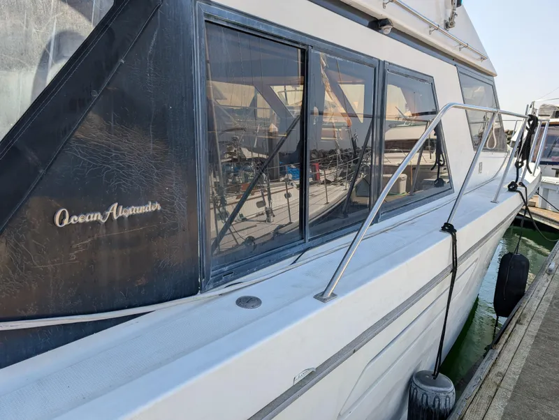 Slide: The Image of 1986 Ocean Alexander 39 Sedan yacht docked, showcasing sleek design and large windows. - 7