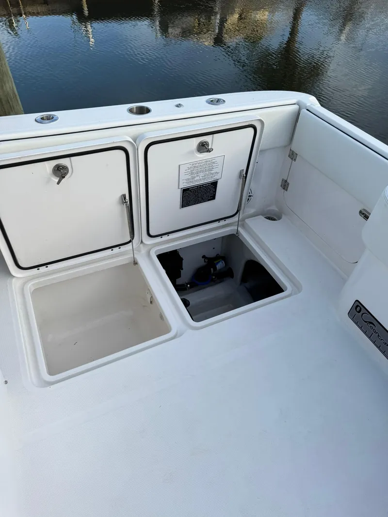 Slide: The Image of 2023 Invincible 33 Catamaran deck with open storage compartments by the water. - 4