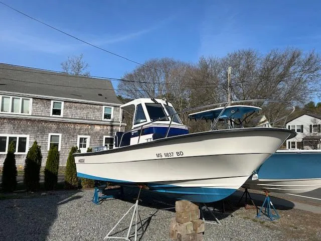 Slide: The Image of 2015 Maritime Skiff 23 Patriot boat on stands, residential background, clear sky. - 11