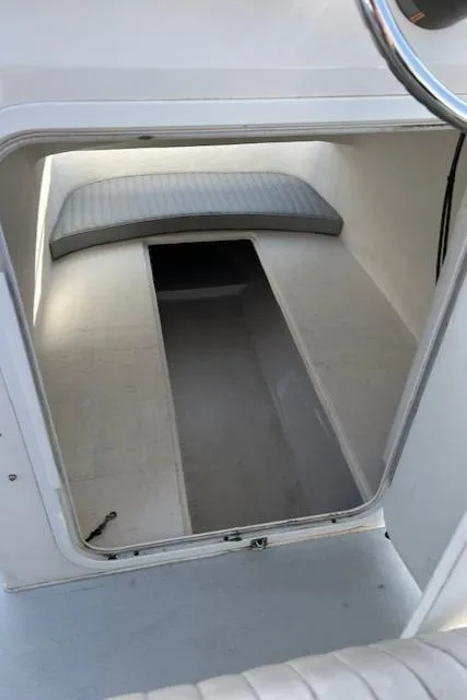 Slide: The Image of 2015 Maritime Skiff 23 Patriot cabin interior with cushioned seating and storage space. - 12