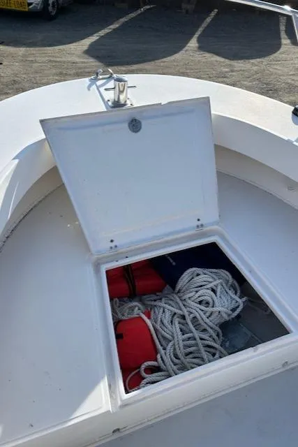Slide: The Image of Open storage compartment on 2015 Maritime Skiff 23 Patriot, containing ropes and life jackets. - 13
