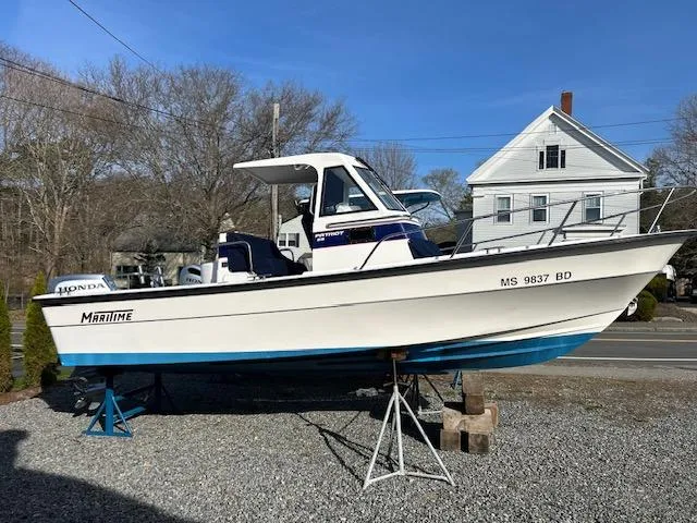 Slide: The Image of 2015 Maritime Skiff 23 Patriot boat on stands, parked outdoors. - 14