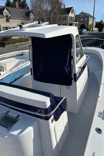 Slide: The Image of 2015 Maritime Skiff 23 Patriot boat with covered cabin, docked in a residential area. - 16