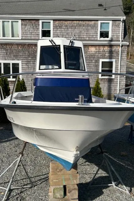 Slide: The Image of 2015 Maritime Skiff 23 Patriot boat on stands, in front of a shingled house. - 19