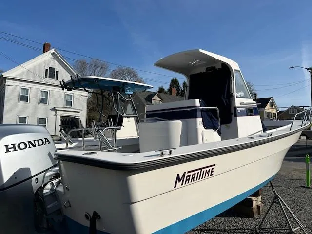 Slide: The Image of 2015 Maritime Skiff 23 Patriot boat with Honda outboard motor, parked outdoors. - 4