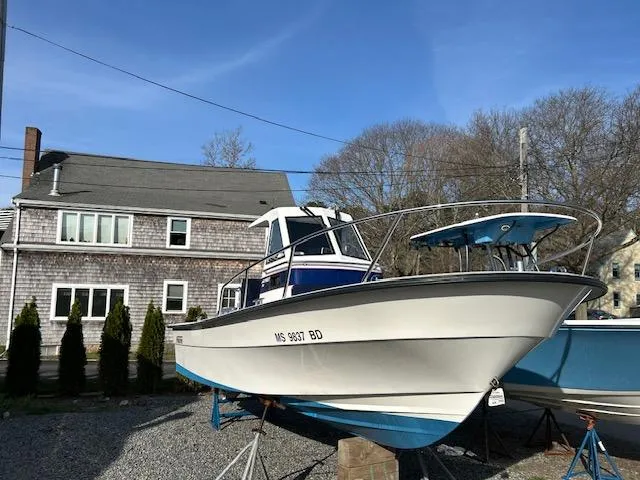 Slide: The Image of 2015 Maritime Skiff 23 Patriot boat on display, parked near a house. - 9