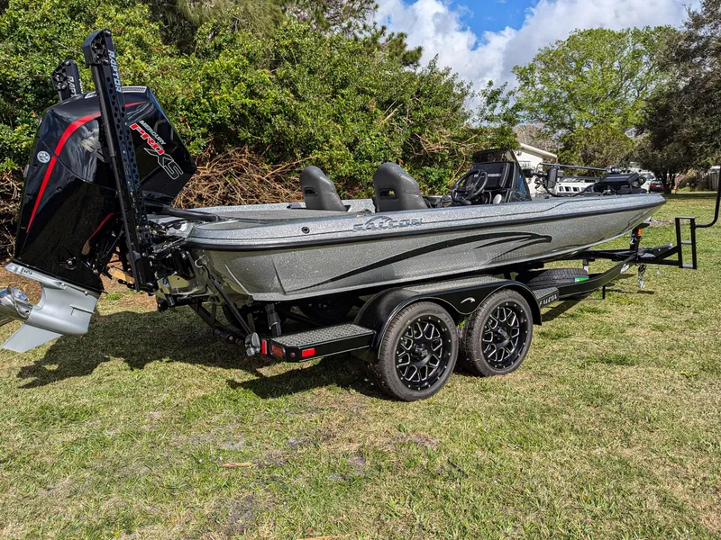 Slide: The Image of 2025 Falcon F20 PREDATOR boat on trailer, parked on grass, with outboard motor. - 0