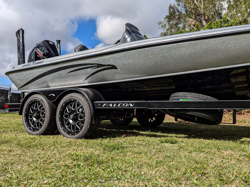 Slide: The Image of 2025 Falcon F20 PREDATOR boat on trailer, parked on grass under a cloudy sky. - 5