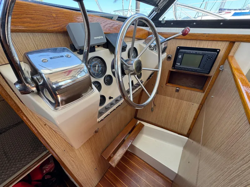 Slide: The Image of 1988 Bertram 28 Sport Fisherman helm with steering wheel, controls, and navigation equipment. - 11