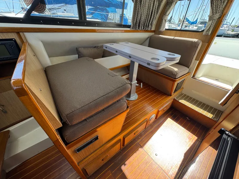 Slide: The Image of 1988 Bertram 28 Sport Fisherman interior with cushioned seating and wooden flooring. - 12