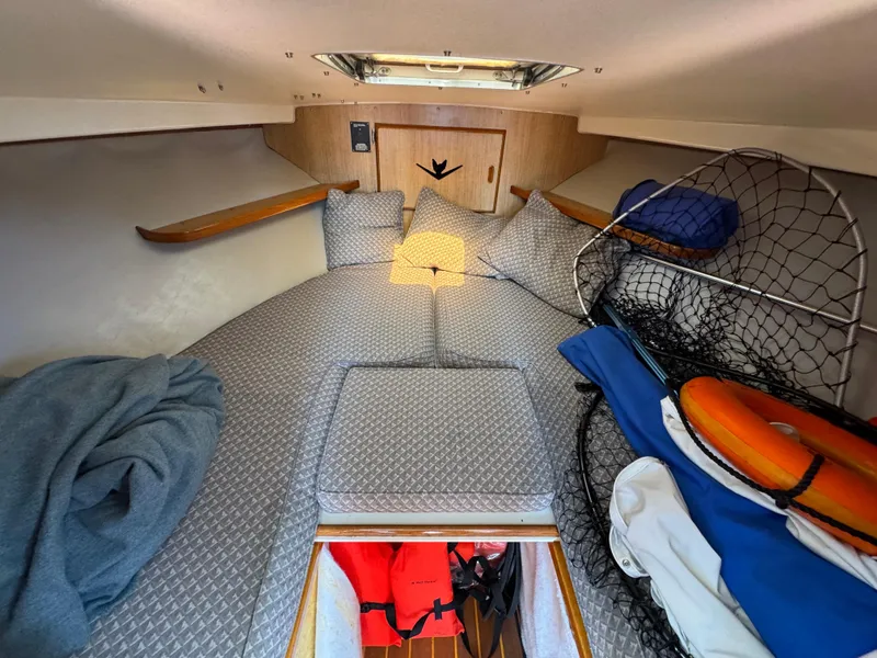 Slide: The Image of 1988 Bertram 28 Sport Fisherman cabin interior with cozy bedding and fishing gear. - 14