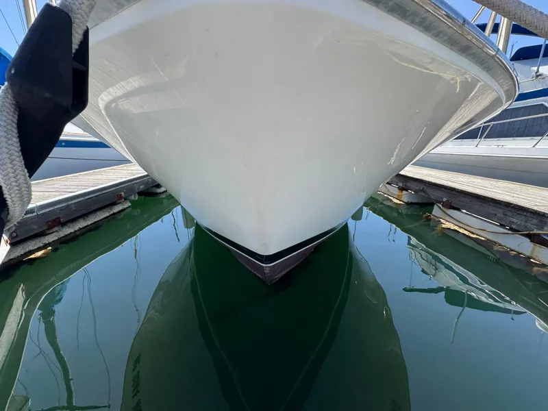 Slide: The Image of 1988 Bertram 28 Sport Fisherman boat docked, reflecting on calm water. - 2