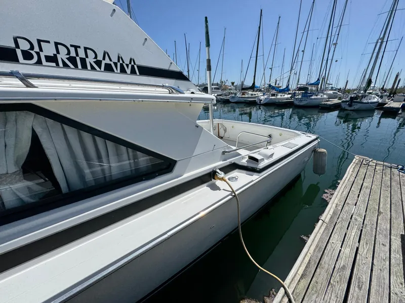 Slide: The Image of 1988 Bertram 28 Sport Fisherman docked at marina with sailboats in background. - 20