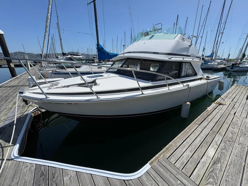 Slide: The Image of 1988 Bertram 28 Sport Fisherman docked at a marina, surrounded by sailboats. - 22