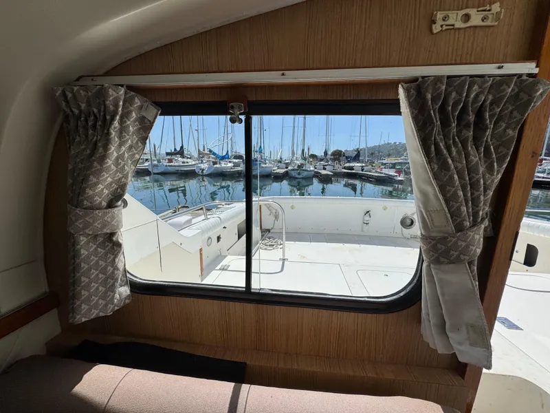 Slide: The Image of Interior view from a 1988 Bertram 28 Sport Fisherman, overlooking a marina through a window. - 8