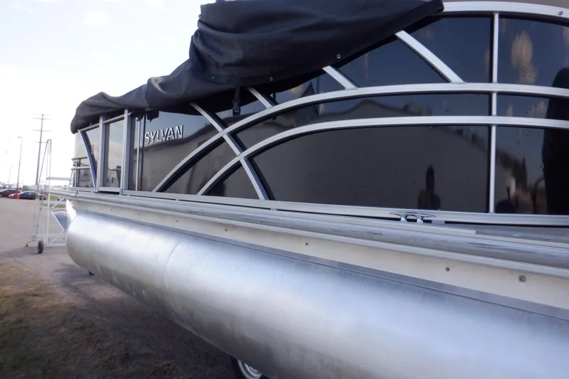 Slide: The Image of 2021 Sylvan Mirage 820 LZ pontoon boat with sleek black exterior and protective cover. - 10