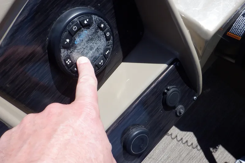 Slide: The Image of Control panel of 2021 Sylvan Mirage 820 LZ pontoon boat with hand pressing button. - 23