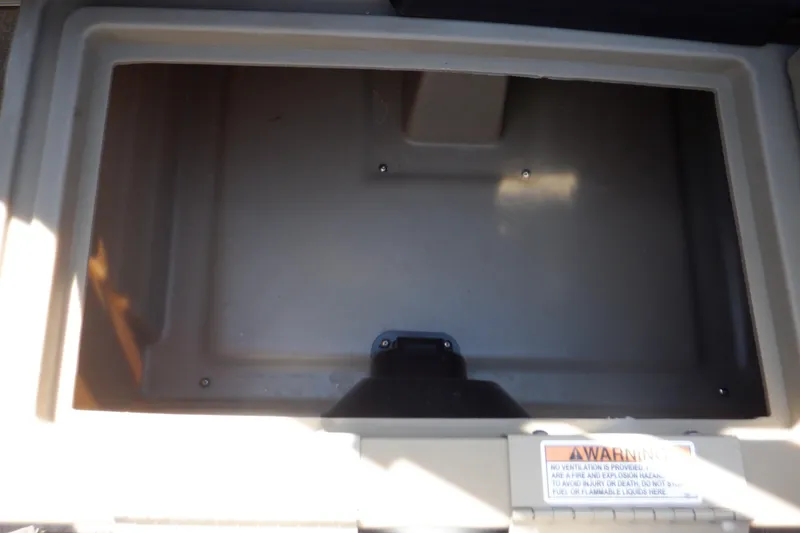 Slide: The Image of Storage compartment of 2021 Sylvan Mirage 820 LZ boat, featuring a warning label. - 26