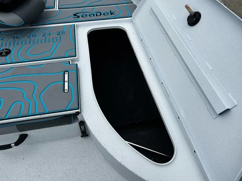 Slide: The Image of 2025 Xpress X23B Lounge boat interior with SeaDek flooring and storage compartment. - 12