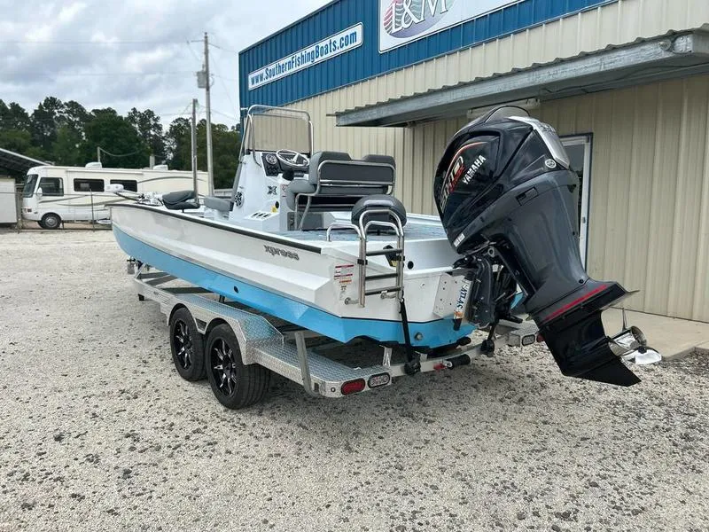 Slide: The Image of 2025 Xpress X23B Lounge boat on trailer with Yamaha outboard motor, parked outside dealership. - 3