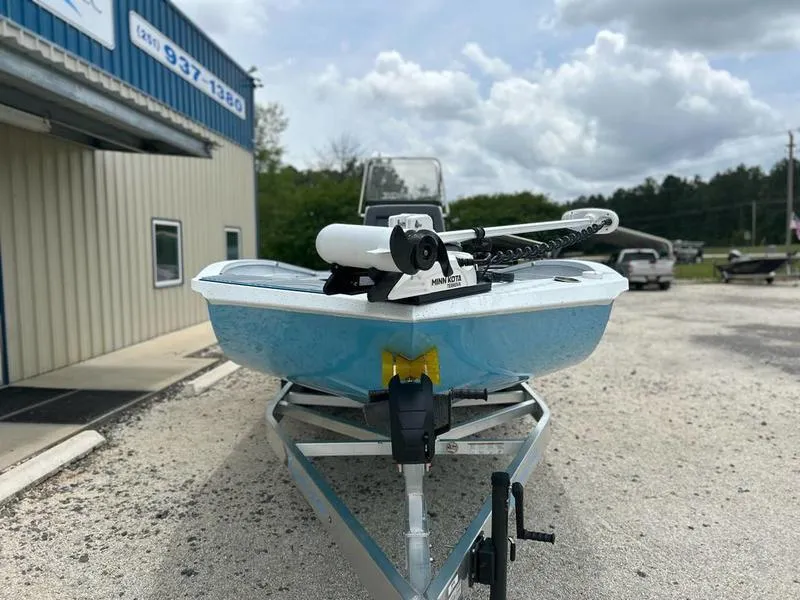 Slide: The Image of 2025 Xpress X23B Lounge boat on trailer, parked outside a building under cloudy sky. - 4