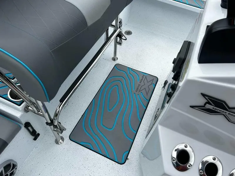 Slide: The Image of 2025 Xpress X23B Lounge boat interior with stylish seating and custom floor mat design. - 7