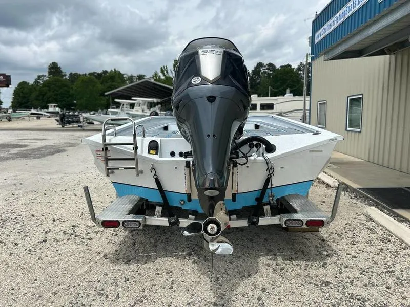 Slide: The Image of 2025 Xpress X23B Lounge boat with outboard motor, parked outdoors. - 8