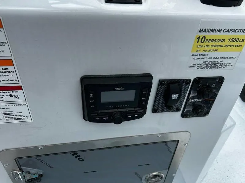 Slide: The Image of Control panel of 2025 Xpress X23B Lounge boat with capacity and safety labels. - 9