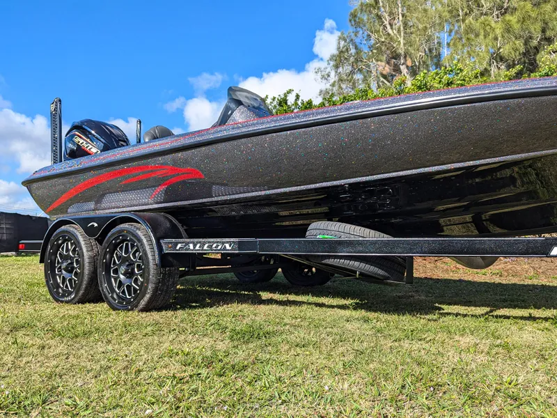 Slide: The Image of 2025 Falcon F20 PREDATOR boat on trailer, sleek design, parked on grass under blue sky. - 2