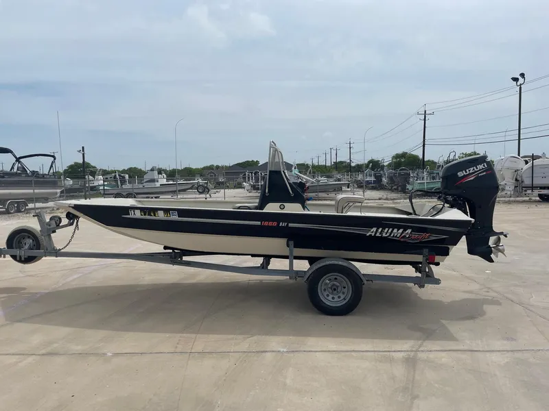 Slide: The Image of 2017 Alumacraft 1860 BAY CC TUNNEL boat on trailer, parked outdoors. - 1