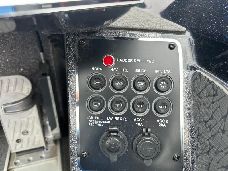 Slide: The Image of Control panel of a 2025 Vexus VXS21 boat with various switches and indicators. - 19