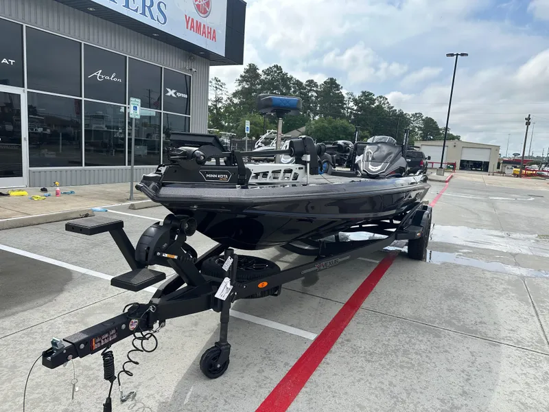 Slide: The Image of 2025 Vexus VXS21 boat on trailer outside dealership, featuring Minn Kota trolling motor. - 33