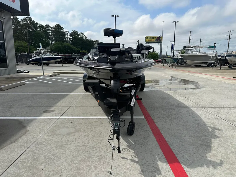 Slide: The Image of 2025 Vexus VXS21 boat on trailer in parking lot, surrounded by other boats. - 34