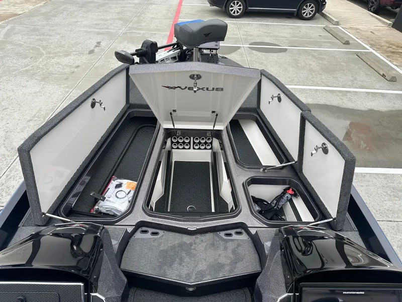 Slide: The Image of 2025 Vexus VXS21 boat with open storage compartments in a parking lot. - 8