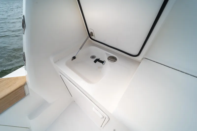 Slide: The Image of 2004 Ocean Yachts 50 Super Sport boat sink area with storage compartment. - 13