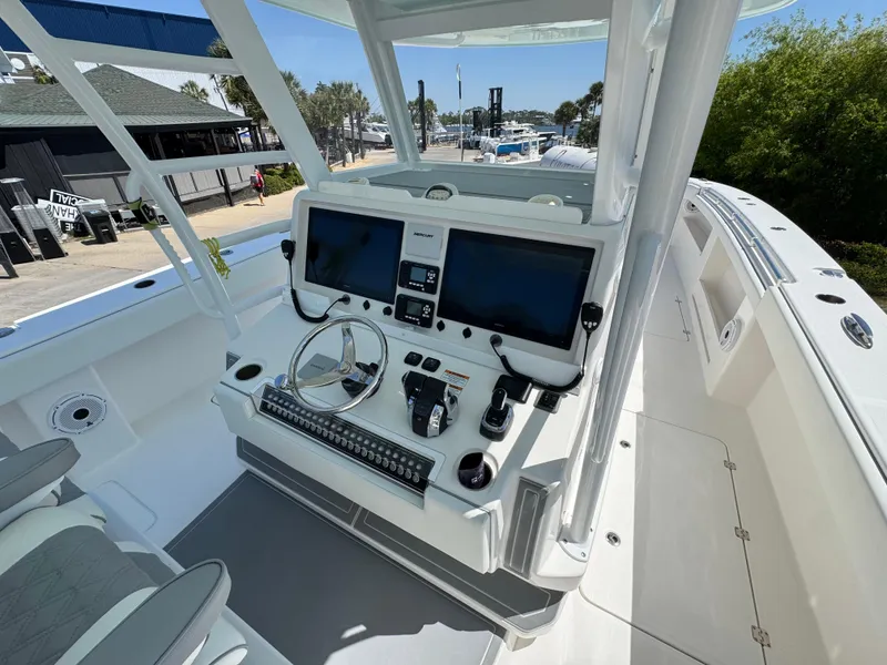Slide: The Image of Invincible 46 Catamaran 2022 helm with dual screens and controls, dockside view. - 7