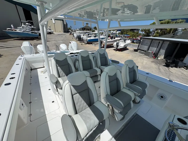 Slide: The Image of 2022 Invincible 46 Catamaran with luxurious seating, docked at a marina. - 8
