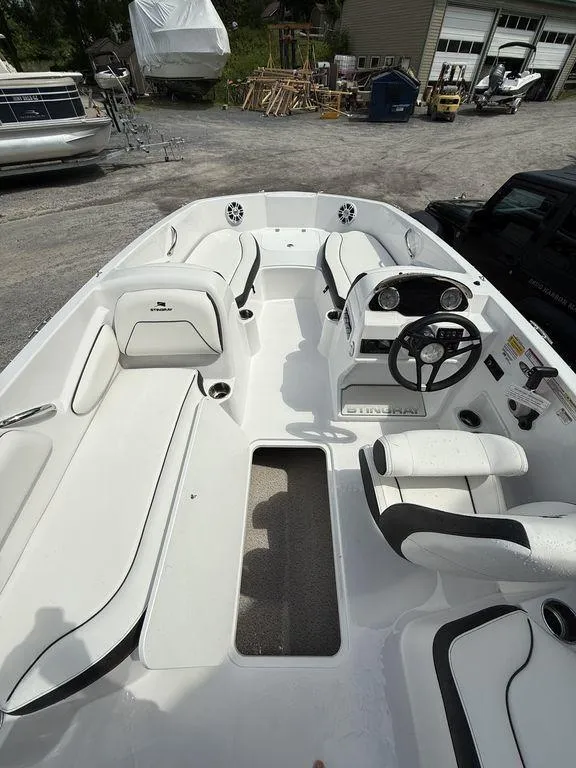 Slide: The Image of 2025 Stingray 182SC boat interior with white seating and steering console. - 15