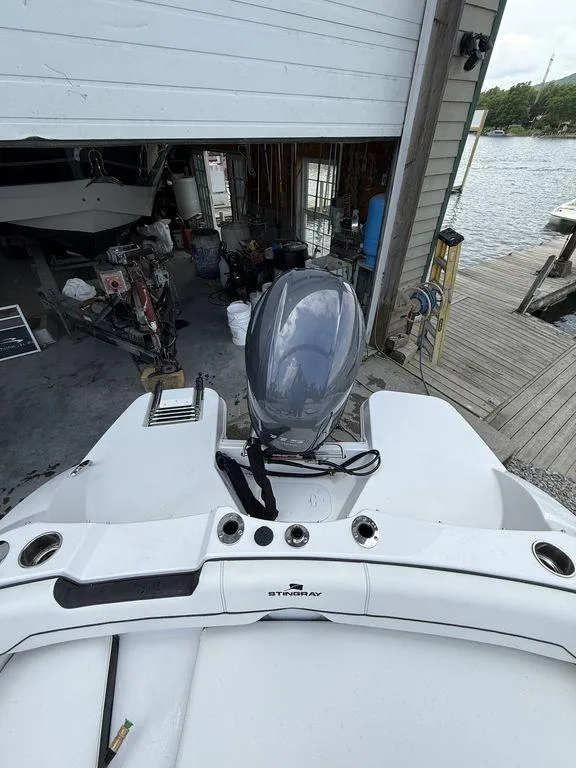 Slide: The Image of 2025 Stingray 182SC boat with outboard motor near a dock and boathouse. - 19