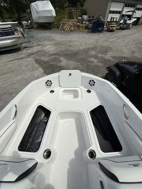 Slide: The Image of 2025 Stingray 182SC boat interior with storage compartments and speakers, parked outdoors. - 20