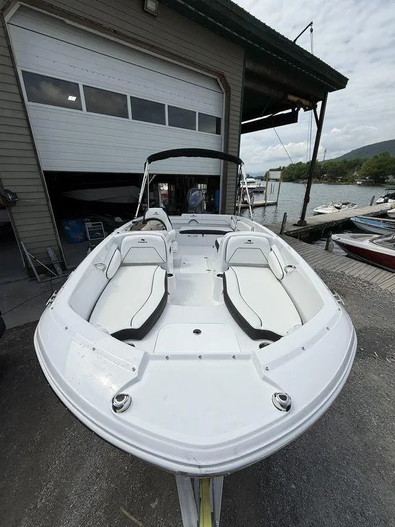 Slide: The Image of 2025 Stingray 182SC boat docked near a boathouse, showcasing sleek white design. - 23