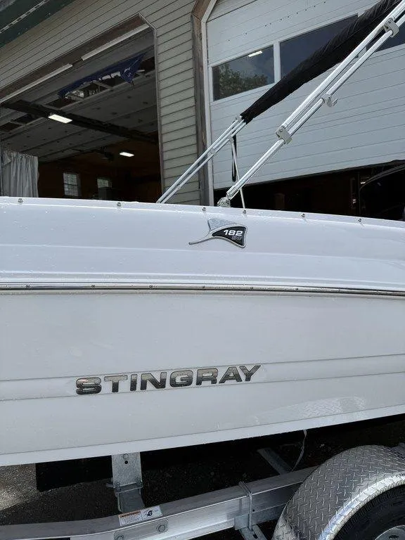 Slide: The Image of 2025 Stingray 182SC boat side view with logo, parked on a trailer. - 6