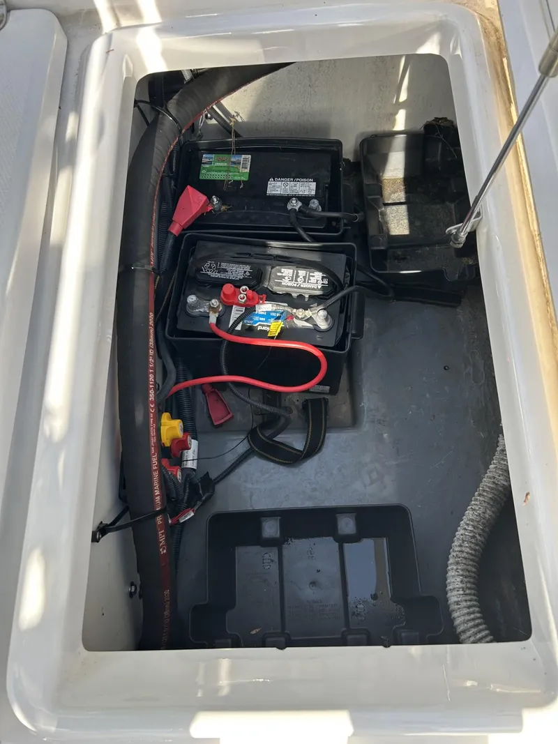 Slide: The Image of 2021 Yamaha Boats 195 FSH Sport battery compartment with wiring and components. - 6