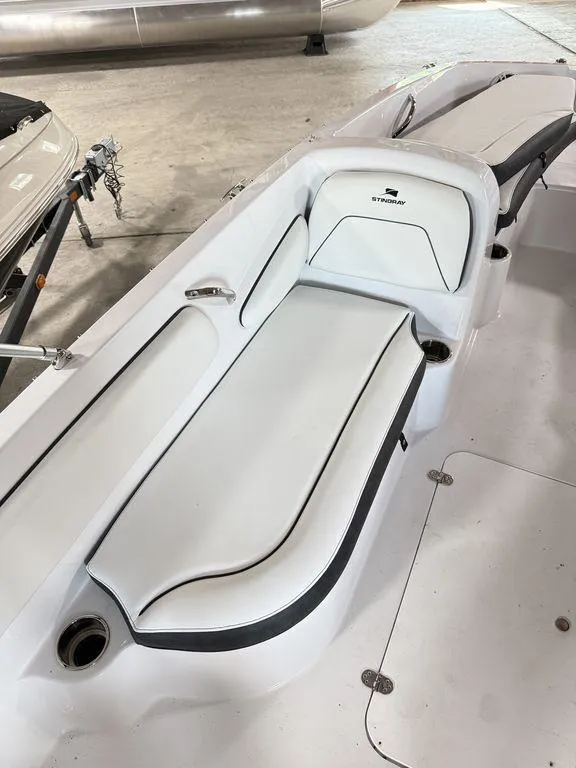 Slide: The Image of 2025 Stingray 182SC boat interior with white seating and black trim. - 10