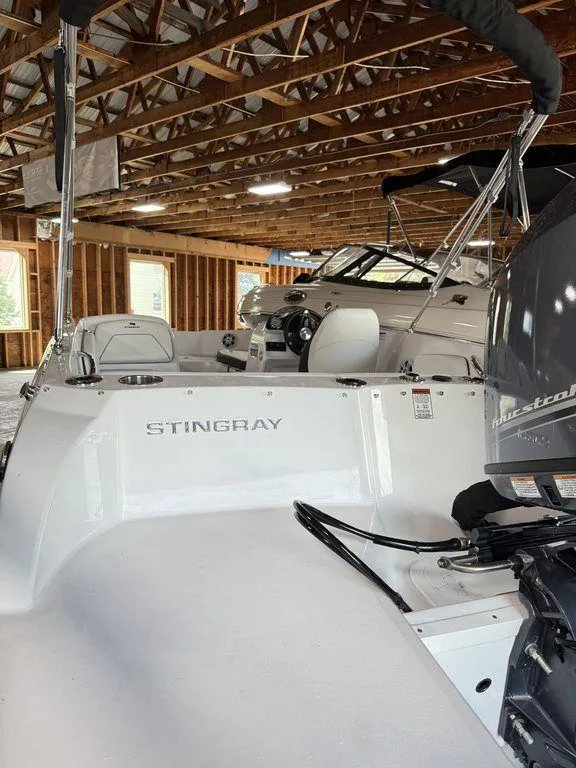 Slide: The Image of 2025 Stingray 182SC boat in wooden storage facility, showcasing sleek design and modern features. - 12