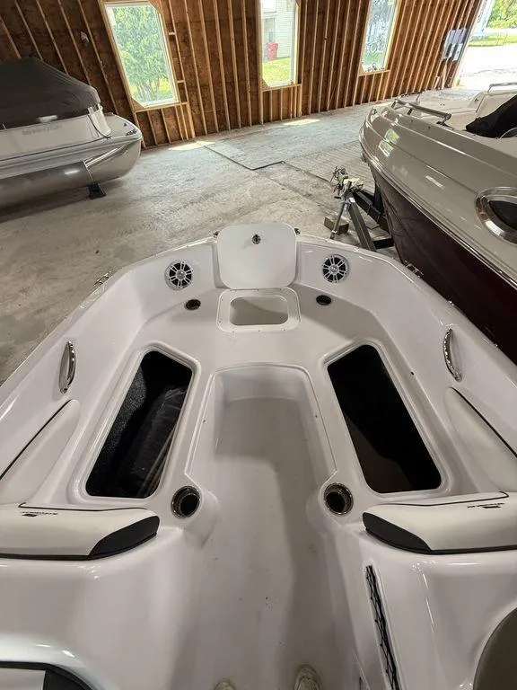 Slide: The Image of 2025 Stingray 182SC boat interior with seating and storage compartments in a showroom. - 23