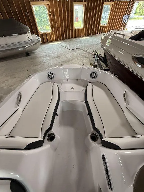 Slide: The Image of 2025 Stingray 182SC boat interior with white seating in a wooden boathouse. - 24