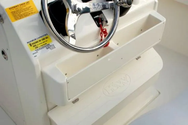 Slide: The Image of 2023 Key West 239 FS boat console with steering wheel and storage compartments. - 5